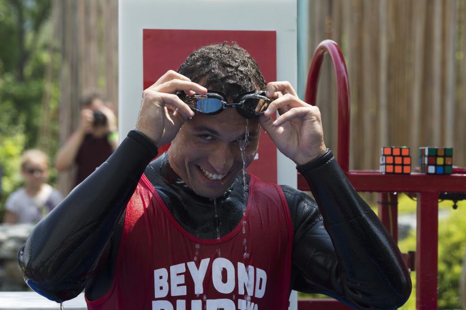 North American Speed Cube Champion Anthony Brooks reacts after breaking the Guinness World Records title for "Most Cubes Solved Underwater In One Breath" at the National Rubik's Cube Championship at Liberty Science Center in Jersey City