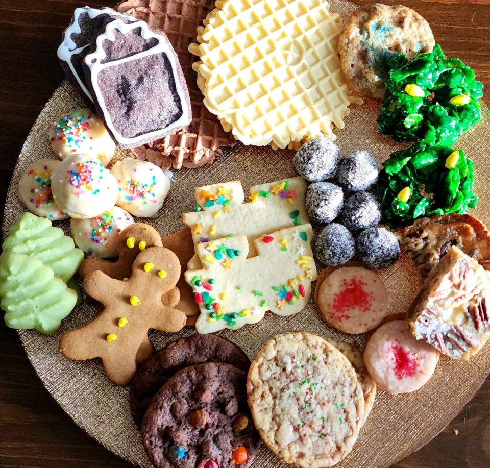 A Christmas cookie tray includes gingerbread men, sugar cookies, spritz trees, bourbon balls, cornflake wreaths and anise cookies.