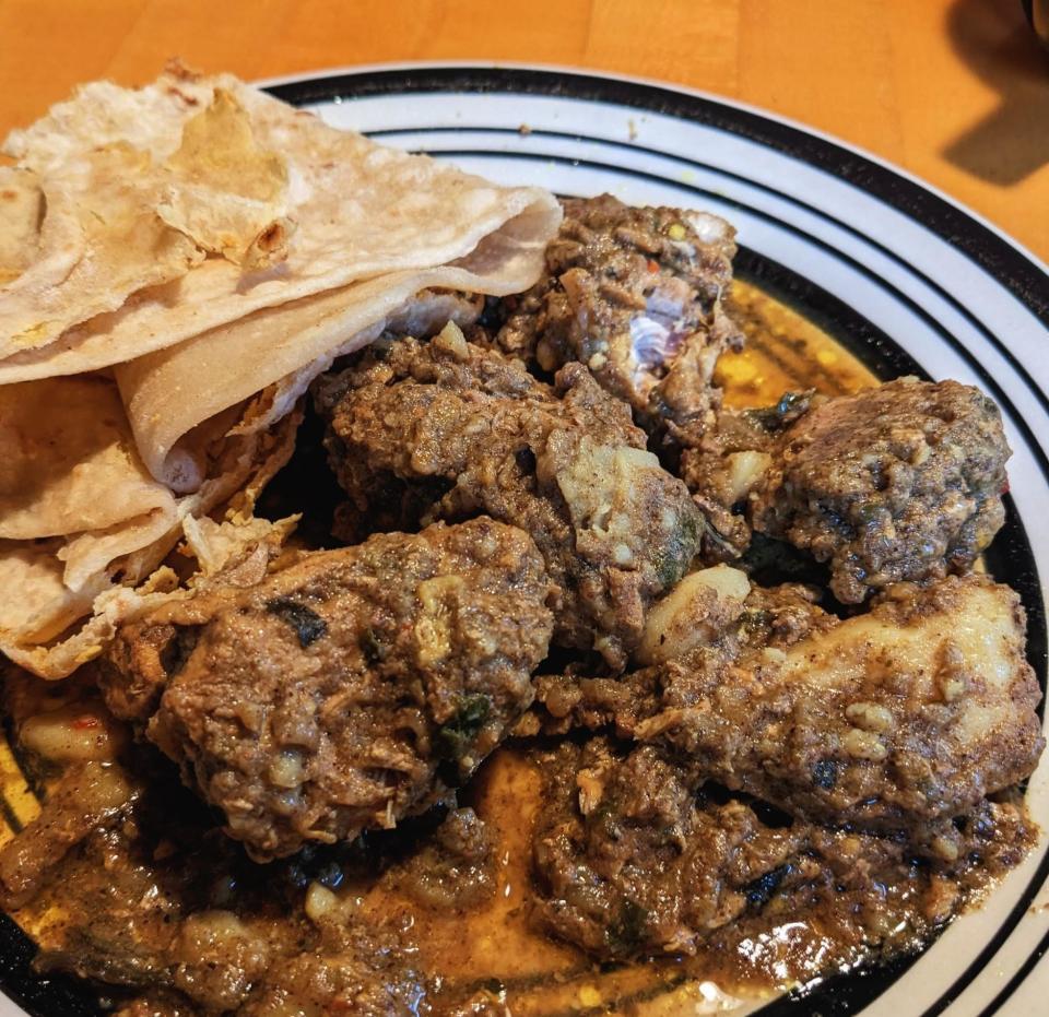 trinidadian curry chicken served with a side of roti