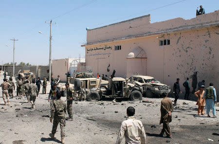 Afghan National Army (ANA) soldiers inspect damaged army vehicles after a suicide attack in Lashkar Gah, Helmand province, Afghanistan August 23, 2017. REUTERS/Stringer