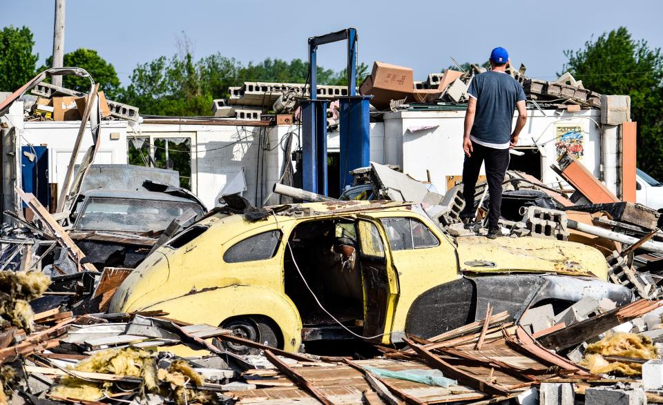 Jason Young looks over the damage at Recreated Automotive at the intersection of Brookville Pyrmont Road and Johnsville Brookville Road Tuesday, May 28 in Brookville. Streets were blocked for downed trees, power lines and debris scattered through the neighborhoods. WHIO File