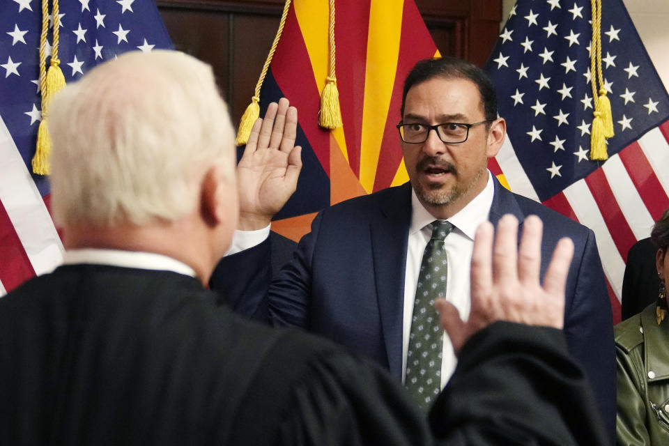 The new Arizona Democratic Secretary of State Adrian Fontes, right, takes the oath of office from Arizona Supreme Court Chief Justice Robert Brutinel, left, in a ceremony at the state Capitol in Phoenix, Monday, Jan. 2, 2023. (AP Photo/Ross D. Franklin, Pool)