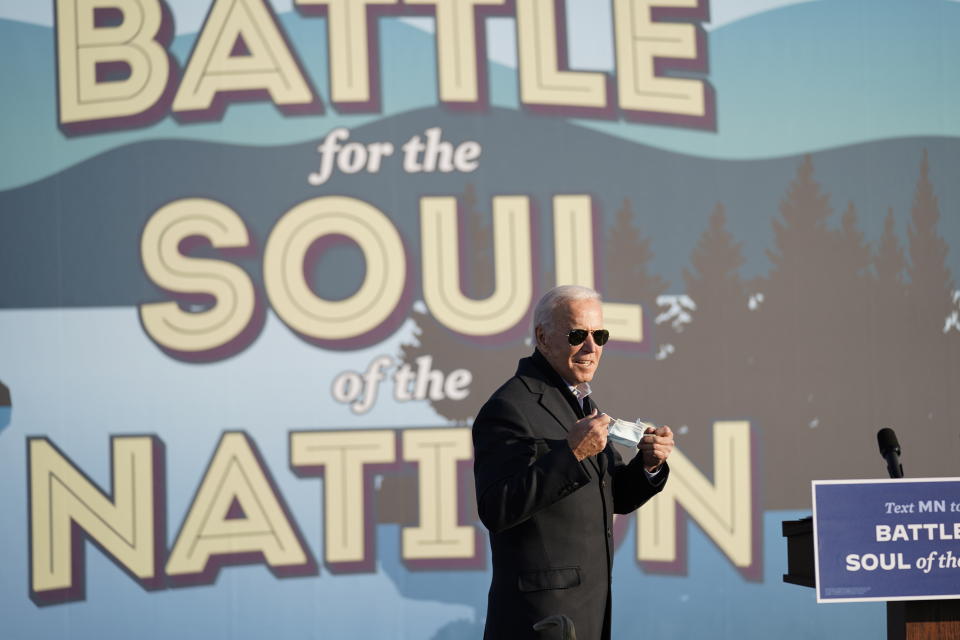 Democratic presidential candidate former Vice President Joe Biden holds his face mask during a rally at the Minnesota State Fairgrounds in St. Paul, Minn., Friday, Oct. 30, 2020. (AP Photo/Andrew Harnik)