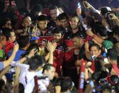 Manny Pacquiao (C), the playing coach of KIA-Sorento, is greeted by fans along with his teammates during the opening of the 40th Season of the Philippine Basketball Association (PBA) games in Bocaue town, Bulacan province, north of Manila October 19, 2014. Pacquiao, a congressman and a world renowned boxing champion, ventured into the PBA as a playing coach on Sunday. Manny Pacquiao is scheduled for a title bout against Chris Algieri of the U.S. in Macau on November 22. REUTERS/Romeo Ranoco (PHILIPPINES - Tags: POLITICS SPORT BOXING BASKETBALL)