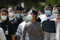 Myanmar leader Aung San Suu Kyi, center, wearing a protective face mask and shield walks to greet supporters as she leaves after a demonstration of the voting for the upcoming Nov. 8 general elections, Tuesday, Oct. 20, 2020, in Naypyitaw, Myanmar. (AP Photo/Aung Shine Oo)