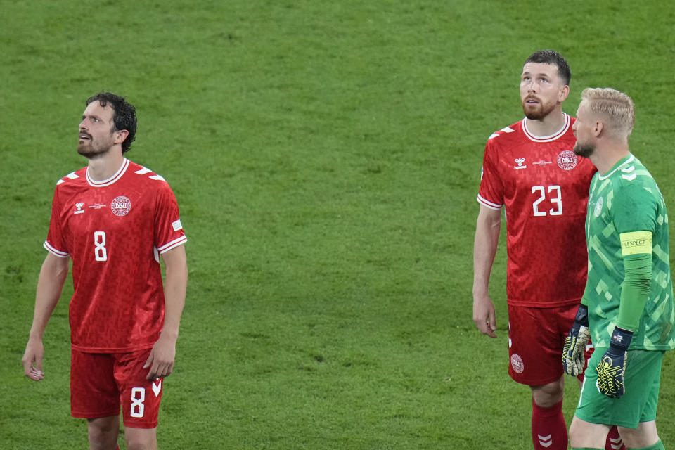 Denmark's Thomas Delaney, left, and Denmark's Pierre-Emile Hojbjerg, center, look up to the stadium roof during a round of sixteen match between Germany and Denmark at the Euro 2024 soccer tournament in Dortmund, Germany, Saturday, June 29, 2024. (AP Photo/Hassan Ammar)