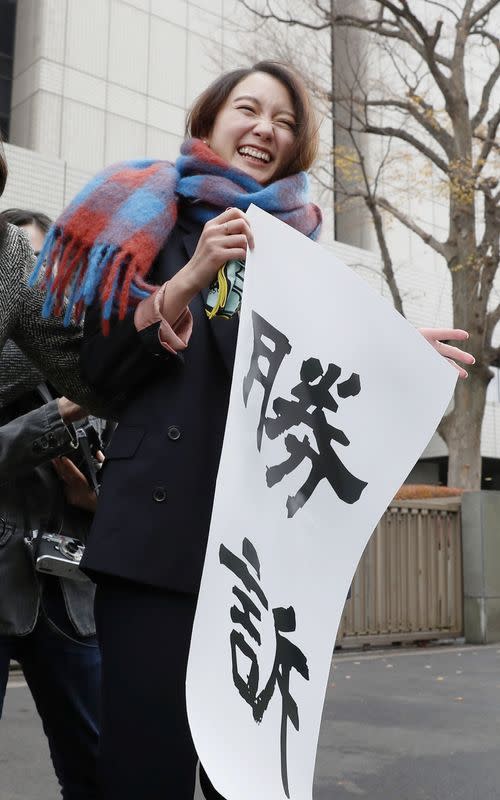 Japanese journalist Shiori Ito holds a banner reading "Victory" outside the Tokyo District Court after a court verdict ordered in Tokyo