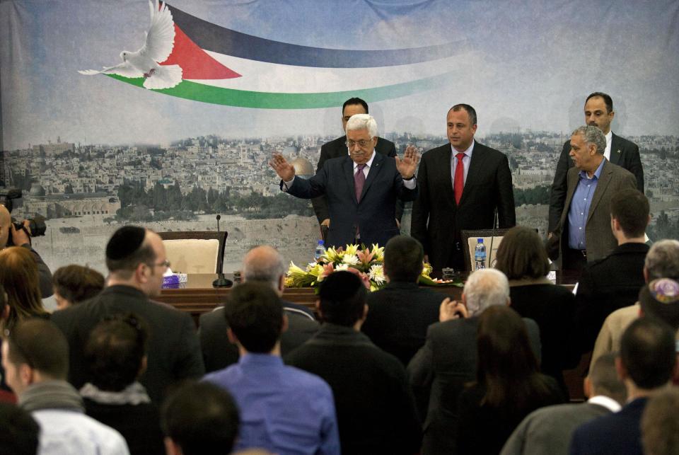 Palestinian President Mahmoud Abbas, top left, and Israeli Labor party lawmaker Hilik Bar, top second left, arrive for a meeting with a delegation of mostly Israeli university students and activists in dovish political parties, at his compound in the West Bank city of Ramallah, Sunday, Feb. 16, 2014. Abbas said that he does not want to "drown Israel with millions of (Palestinian) refugees to change its nature." Abbas' comment Sunday was his most conciliatory yet on the fate of Palestinian refugees who were uprooted from homes in what is now Israel, including in the 1948 war over Israel's creation. (AP Photo/Nasser Nasser)