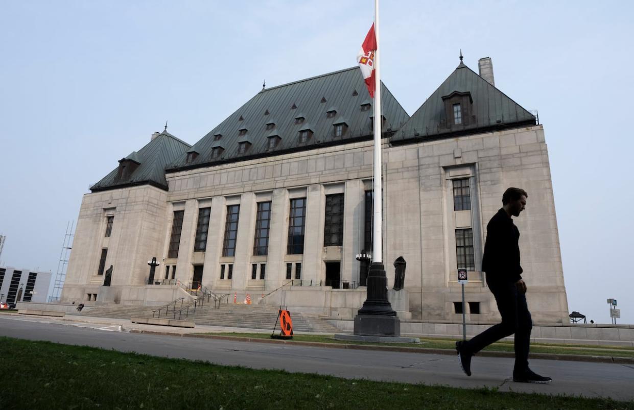 A man walks past the Supreme Court of Canada in a file photo from June. The court is set to release its judgment on the federal government's environmental impact legislation on Friday. (Adrian Wyld/The Canadian Press - image credit)