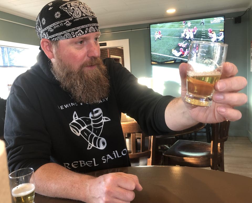 Rebel Sailor Brewing Co. Head Brewer Robert Payne shows the Reindeer P, a blonde ale sourced with honey from the nearby Shortsville Reindeer Farm.