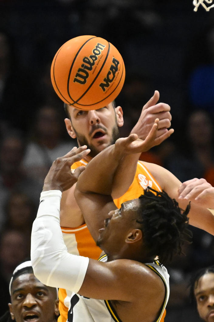 Tennessee forward Uros Plavsic, top, and Missouri guard DeAndre Gholston vie for a rebound during the second half of an NCAA college basketball game in the quarterfinals of the Southeastern Conference Tournament, Friday, March 10, 2023, in Nashville, Tenn. Missouri won 79-71. (AP Photo/John Amis)