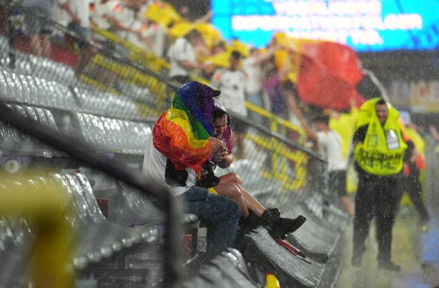 Fans feel the full force of the heavy rainfall during the suspension of play