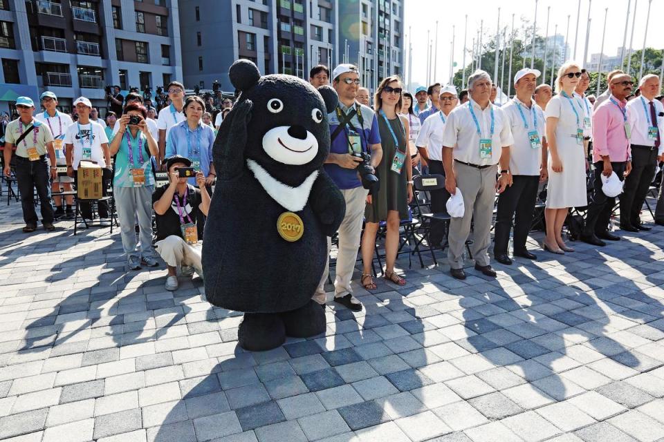 台北市吉祥物「熊讚」（左）現身林口選手村開村儀式，為市府的喜事添光彩。