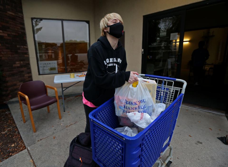 Rowan Van Patten, 19, from Davenport, Iowa,  a Milwaukee Institute of Art & Design, student, checks out food received from the Interchange Food Pantry. Van Patten who doesn’t receive assistance from family, is struggling financially with cost at MIAD and the weekly cost of meals and sought assistance at the food pantries. Van Patten was especially excited to see the cheese pizza.