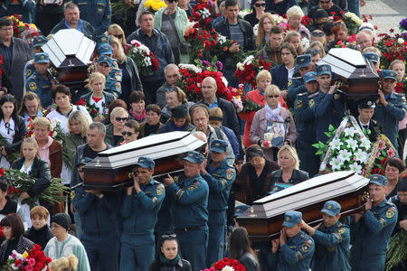 Russian Emergencies Ministry members carry a coffin during a memorial ceremony before the funeral of victims of an attack on a local college in the city of Kerch, Crimea October 19, 2018. REUTERS/Pavel Rebrov