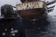 In this July 2021 photo provided by Sea Shepherd, crew members of the Ocean Warrior approach a Chinese-flagged vessel whose Indonesian crew said they had been stuck at sea for years. (Isaac Haslam/Sea Shepherd via AP)