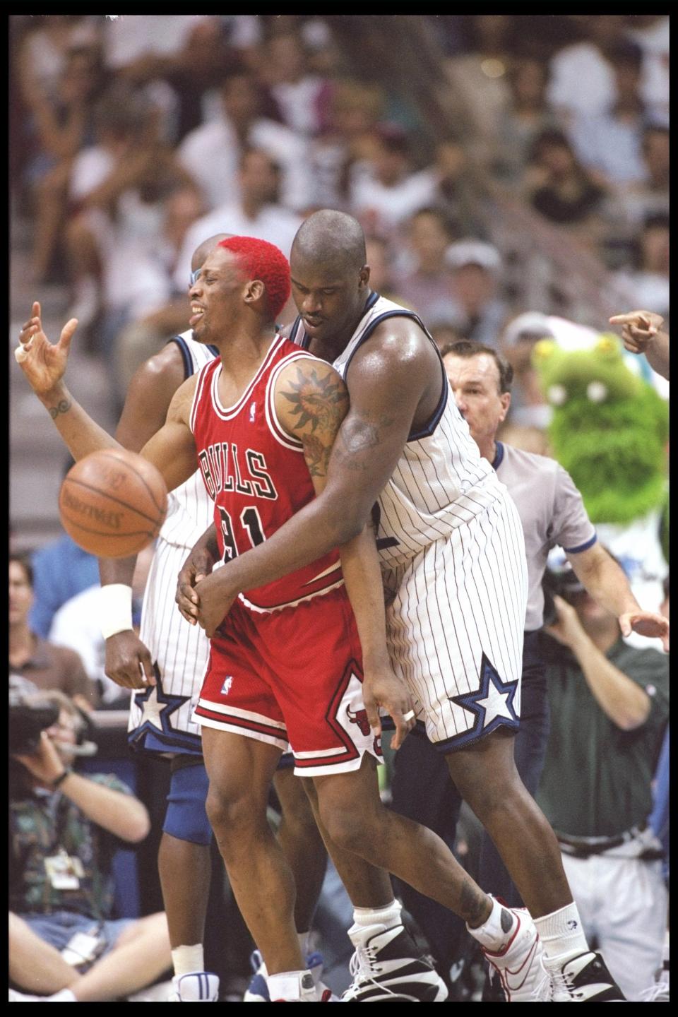 Dennis Rodman of the Chicago Bulls tries to break free of center Shaquille O'Neal of the Orlando Magic during a game at the Orlando Arena in Orlando, Florida on April 7, 1996. (Allsport)