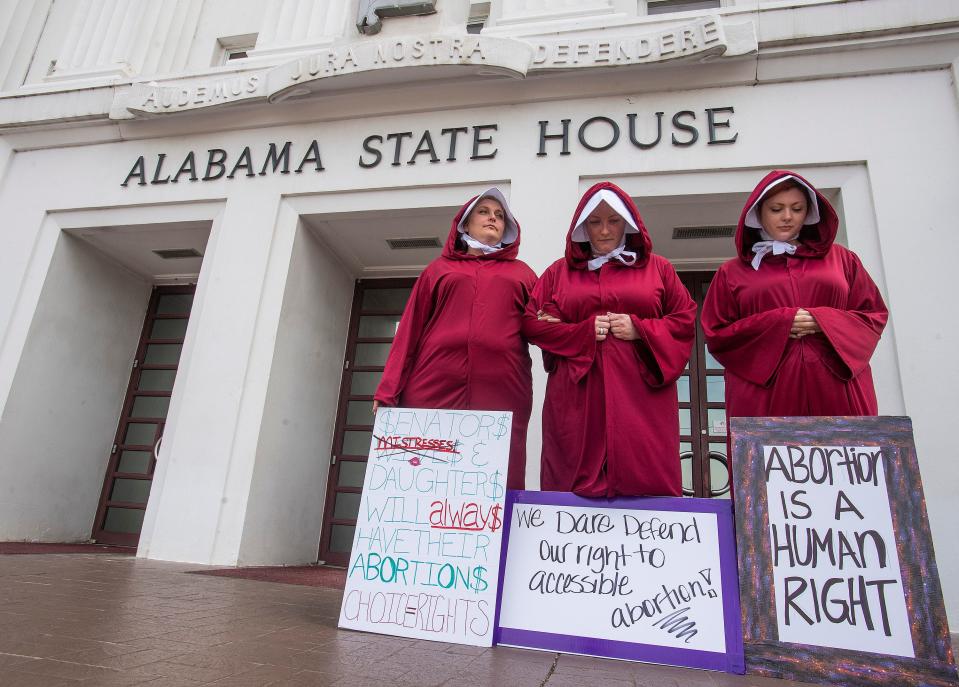 Women dressed as handmaids protest against a near-total abortion ban outside the Alabama State House in Montgomery, Ala., on April 17, 2019.