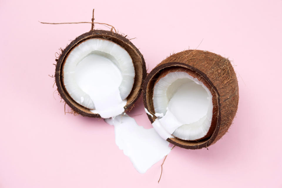 coconut with white liquid paint on a vibrant pink background