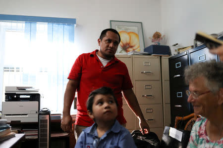 Walter Armando Jimenez Melendez, an asylum seeker from El Salvador, arrives with his four year-old son Jeremy at La Posada Providencia shelter in San Benito, Texas, U.S., shortly after he said they were reunited following separation since late May while in detention July 10, 2018. REUTERS/Loren Elliott