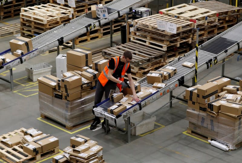 FILE PHOTO: A worker sorts parcels at Amazon's fulfilment centre in Peterborough