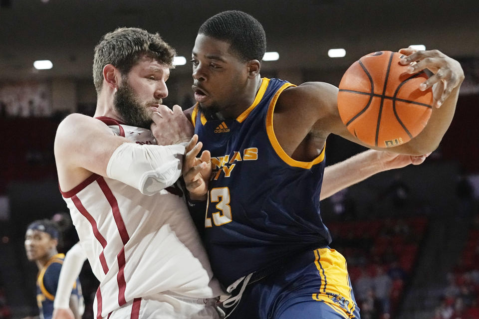 Kansas City forward Allen David Mukeba Jr. drives against Oklahoma forward Tanner Groves, left, in the first half of an NCAA college basketball game, Tuesday, Dec. 6, 2022, in Norman, Okla. (AP Photo/Sue Ogrocki)