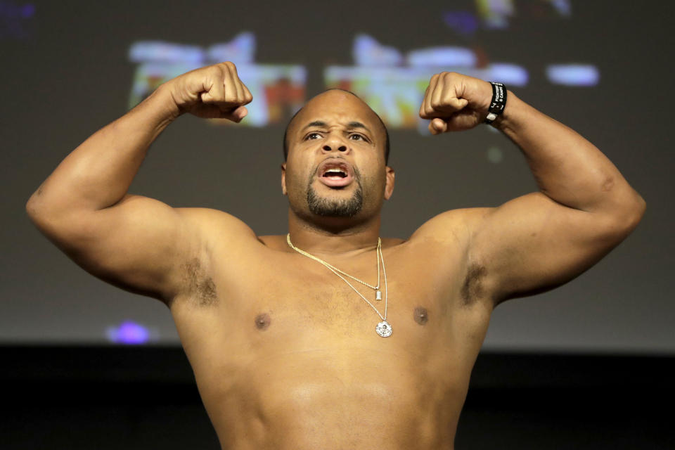 Daniel Cormier reacts while posing atop a scale prior to his heavyweight mixed martial arts bout against Derrick Lewis during the weigh-ins ahead of UFC 230, Friday, Nov. 2, 2018, at Madison Square Garden in New York. (AP Photo/Julio Cortez)