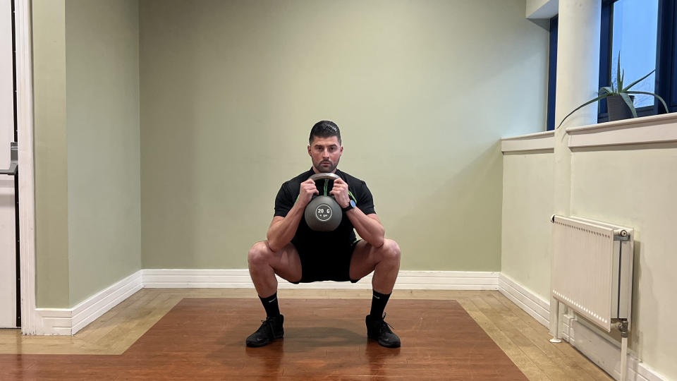 Sam Quinn, a strength coach from Nuffield Health, demonstrates a goblet squat