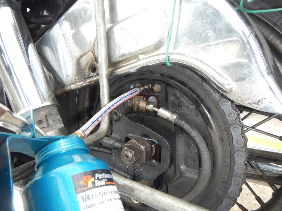 Using an oil can filled with DOT 3, I reverse bled my rear brake.