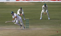 Pakistan's batsman Mohammad Rizwan, left, follows the ball after playing a shot while South Africa's Faf du Plessis, right, and Aiden Markram watches during the second day of the first cricket test match between Pakistan and South Africa at the National Stadium, in Karachi, Pakistan, Wednesday, Jan. 27, 2021. (AP Photo/Anjum Naveed)