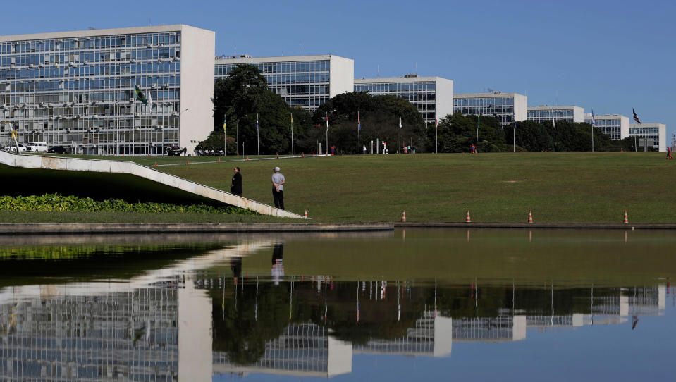 The Esplanada dos Ministerios complex, designed by Brazilian architect Oscar Niemeyer, is reflected in a pool of water in Brasilia. (Eraldo Peres/AP Photo)