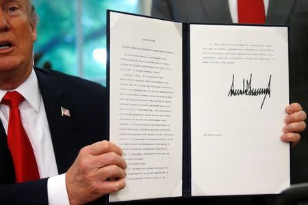 U.S. President Donald Trump displays an executive order on immigration policy after signing it in the Oval Office at the White House in Washington, U.S., June 20, 2018. REUTERS/Leah Millis