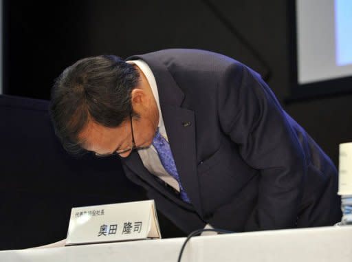 Japan's electronics company Sharp President Takashi Okuda bows his head as he leaves a press conference in Tokyo. Shares in Japanese electronics giant Sharp plunged 30 percent in Tokyo trade on Friday, a day after the company said it would cut 5,000 jobs and reported a huge quarterly loss