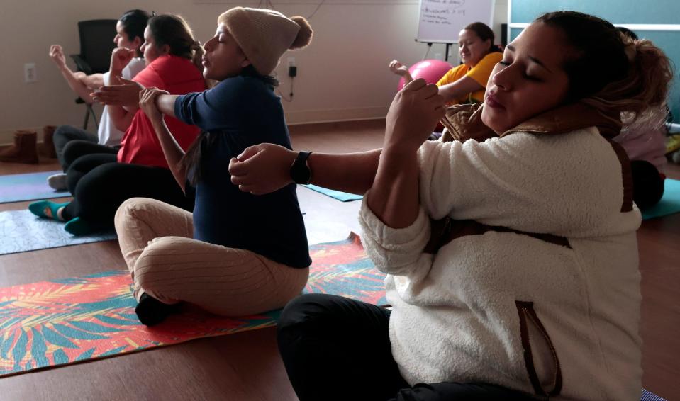 Edith Banos, 29, right, who is in her second trimester, learns about doing yoga for stress relief and relaxation at Covenant Community Care's Centering Pregnancy program in Detroit on Oct. 11, 2023. Centering Pregnancy offers private prenatal care and group learning on the importance of relaxation during pregnancy, and prenatal yoga exercise routines that can be done at home, among other things.