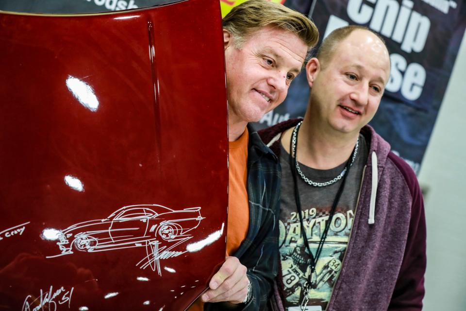 Chip Foose, of the Velocity reality television series Overhaulin, drew a Camaro with his signature on the display test hood of Jamiey Harper, 52, of Waterford, during the 69th annual Meguiar's Detroit Autorama at Huntington Place in downtown Detroit on Friday, March 4, 2022.  800 custom cars will be on display during the car show, including 30 cars competing for the prestigious Ridler Award.