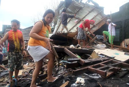 Residents sift through the ruins of their houses along a coastal Pigcale village that was hit by Typhoon Melor, in Legazpi city, Albay province in the Philippines December 15, 2015. REUTERS/Rhaydz Barcia