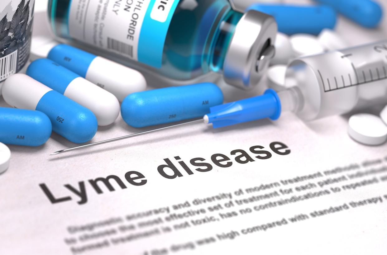 Lyme Disease - Printed Diagnosis with Blurred Text. On Background of Medicaments Composition - Blue Pills, Injections and Syringe.
