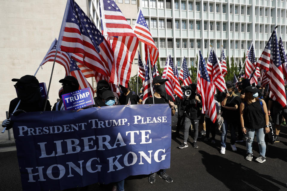 Protesters carrying banner and American flags march to U.S. Consulate during a rally in Hong Kong, Sunday, Dec. 1, 2019. Hong Kong protesters carrying American flags and banners appealing to President Donald Trump rallied in the semi-autonomous Chinese territory. (AP Photo/Vincent Thian)