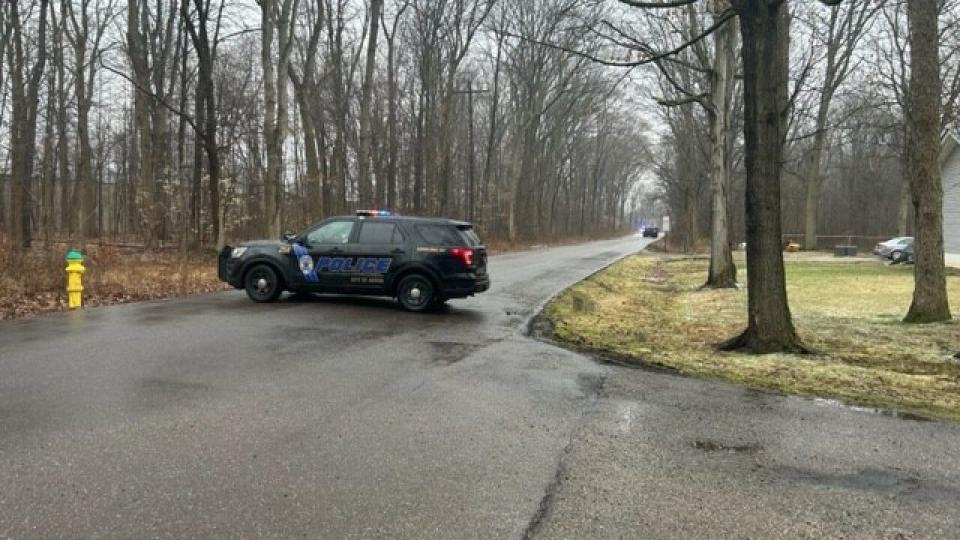 Akron police responding to the scene where two mens' bodies were found in the woods near Cordova Avenue in March 2023.