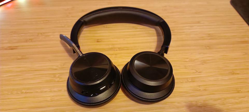 A pair of Poly Voyager Focus 2 headphones on a wooden desk