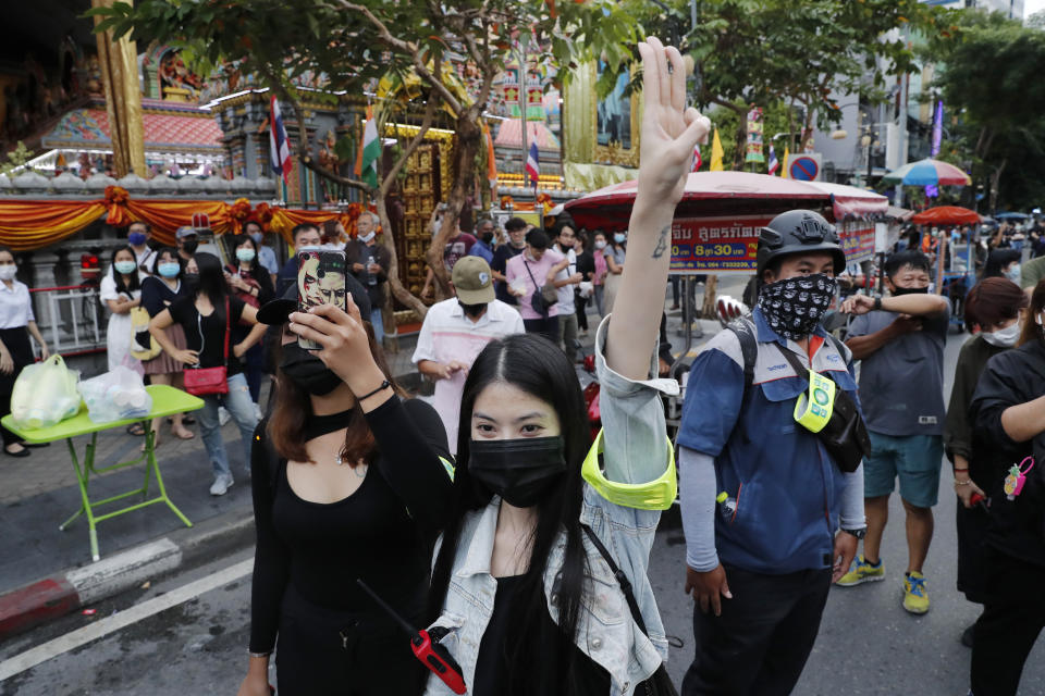 Pro-democracy demonstrators flash a three-finger salute of defiance during a protest rally in the Silom business district of Bangkok, Thailand, Thursday, Oct. 29, 2020. The protesters continue to gather Thursday with their three main demands of Prime Minister Prayuth Chan-ocha's resignation, changes to a constitution that was drafted under military rule and reforms to the constitutional monarchy. (AP Photo/Gemunu Amarasinghe)