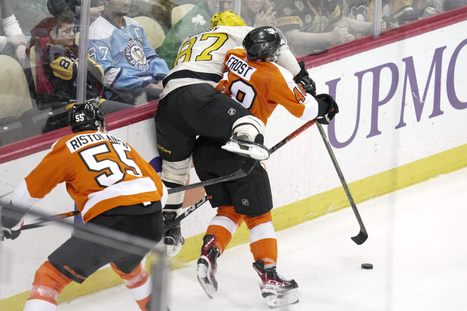 Philadelphia Flyers' Morgan Frost (48) checks Pittsburgh Penguins' Sidney Crosby (87) off the puck during the second period of an NHL hockey game in Pittsburgh, Saturday, March 11, 2023. (AP Photo/Gene J. Puskar)