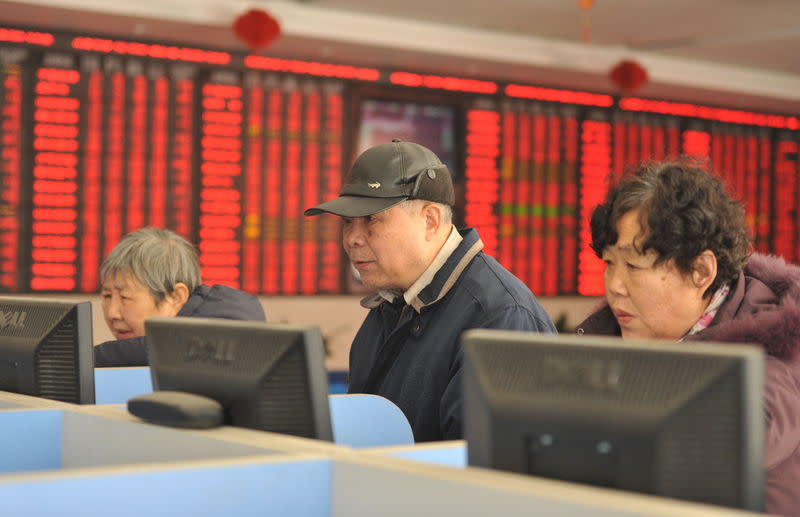 Investors look at computer screens showing stock information at a brokerage house in Fuyang, Anhui province, January 19, 2016. REUTERS/China Daily