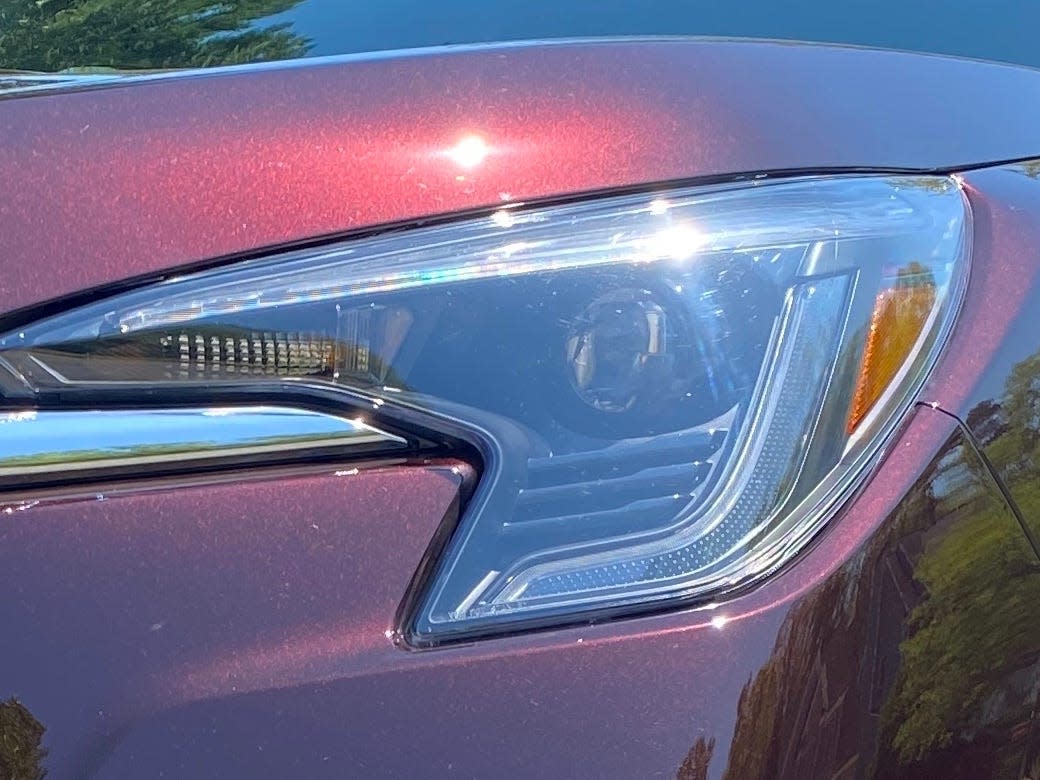 The 2024 Subaru Ascent's updated front facia features a large chrome bar stretched across a blacked-out grille. Subaru's Pleides corporate logo is prominently displayed on the chrome bar.