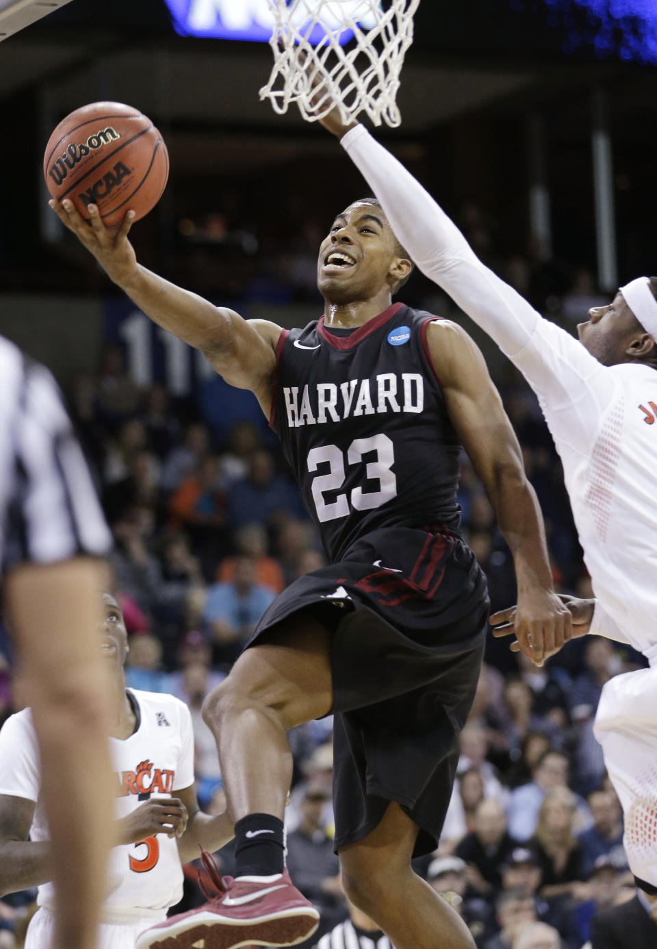 Harvard's Wesley Saunders (23) drives the last past Cincinnati's Justin Jackson in the second half during the second round of the NCAA college basketball tournament in Spokane, Wash., Thursday, March 20, 2014. Harvard won 61-57. (AP Photo/Elaine Thompson)