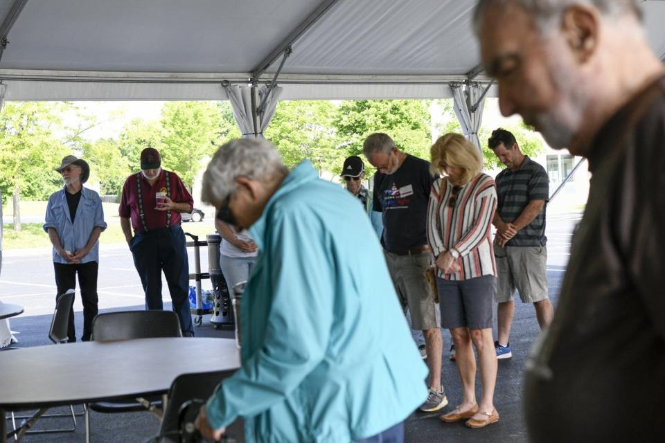 Volunteers say a prayer before the start of the Guns to Gardens event on June 11 at the First Community Church North in Columbus.