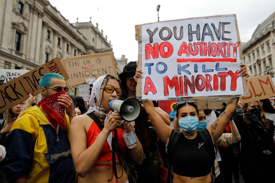 <i>Protesters hold posters and shout slogans as they march in central London on June 3. The sign in the foreground says: "You have no authority to kill a minority."</i>