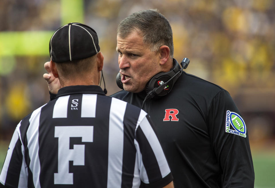 Rutgers head coach Greg Schiano speaks with a sideline official in the first quarter of an NCAA college football game against Michigan in Ann Arbor, Mich., Saturday, Sept. 25, 2021. (AP Photo/Tony Ding)