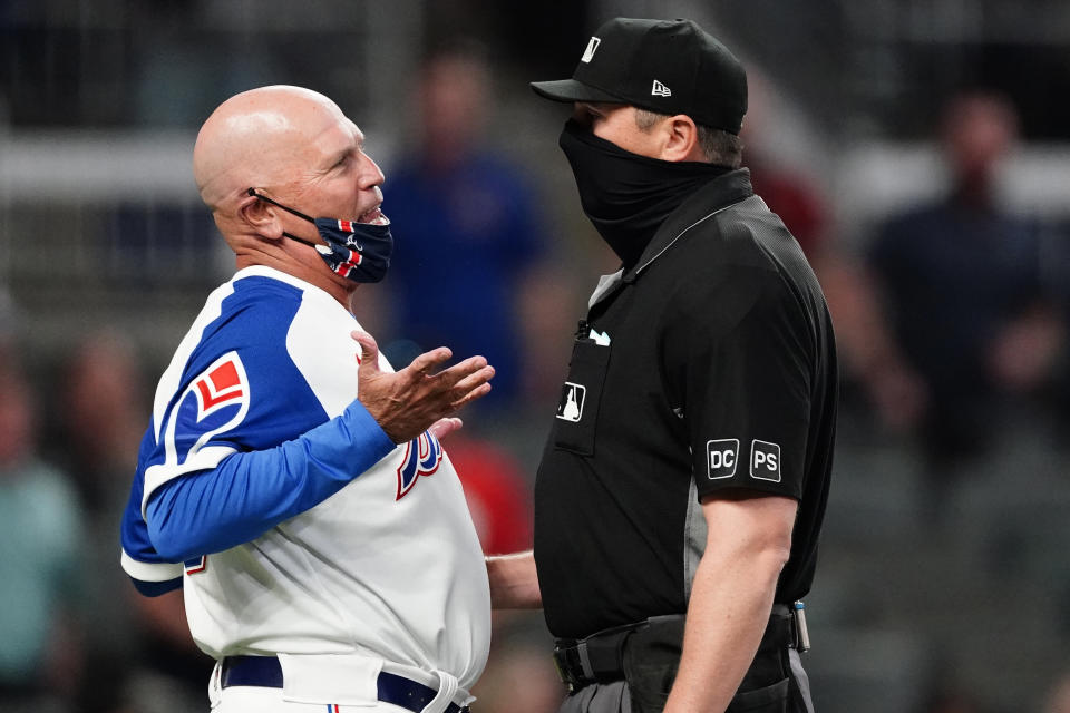 Atlanta Braves manager Brian Snitker, left, argues with umpire Lance Barrett, right, after the Philadelphia Phillies scored a run in the ninth inning of a baseball game Sunday, April 11, 2021, in Atlanta. (AP Photo/John Bazemore)