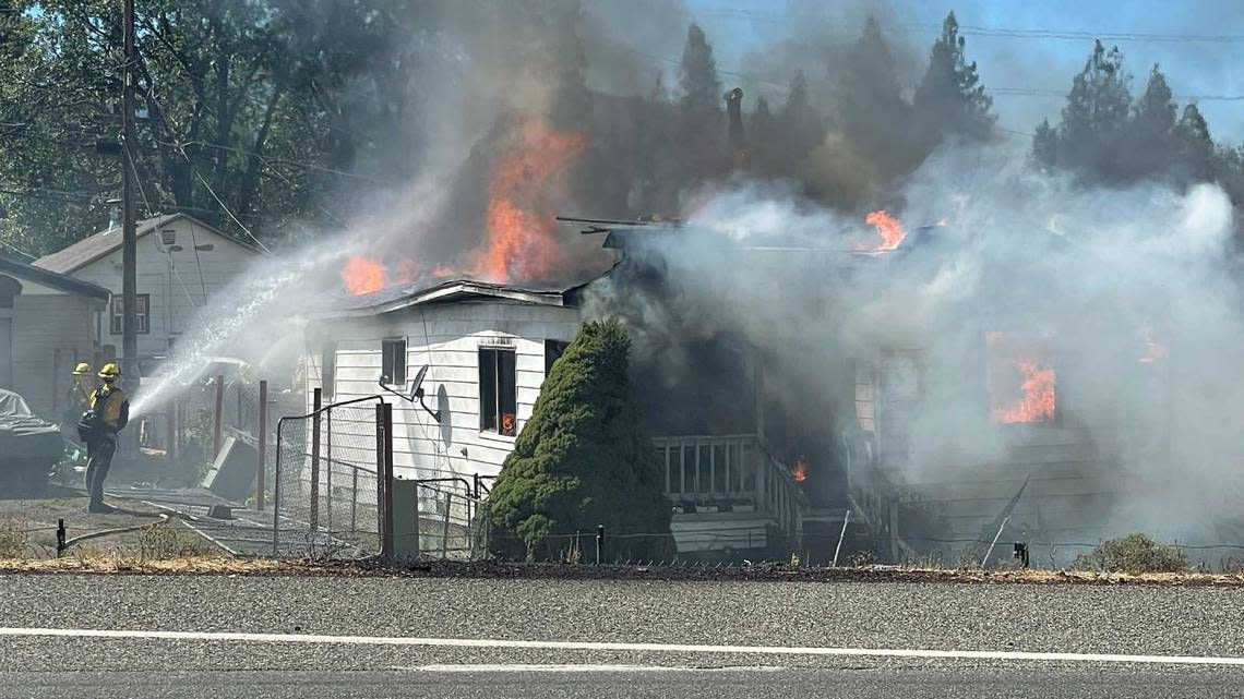 Firefighters battle flames at a home burned by the Mill Fire near Weed, Calif., on Friday, Sept. 2, 2022. The wildfire erupted at a timber mill near the town of Weed in Siskiyou County on Friday, prompting evacuations across a wide area and closing Highway 97.